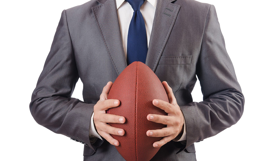 Professional man wearing suit while holding a ball
