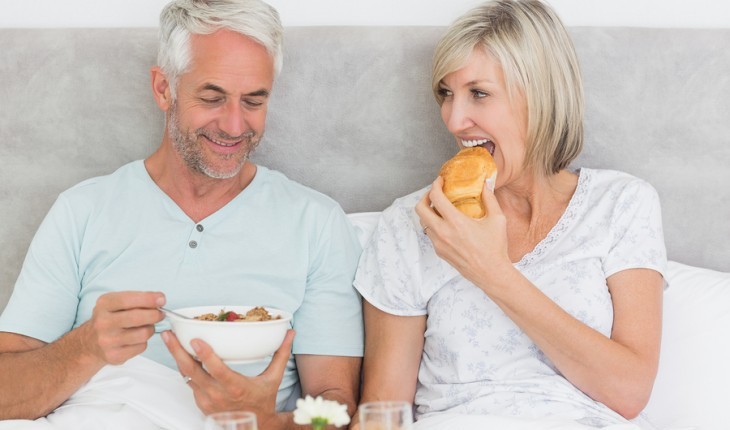 Couple eating in bed together