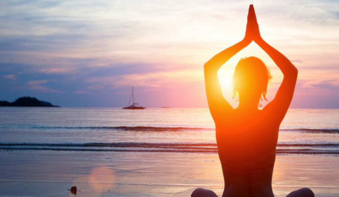 Yoga while on the beach with the sunset