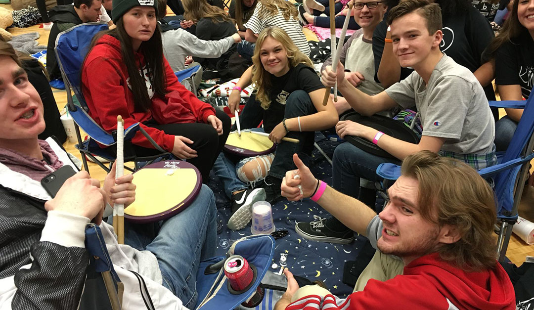 Group holding a drum sticks