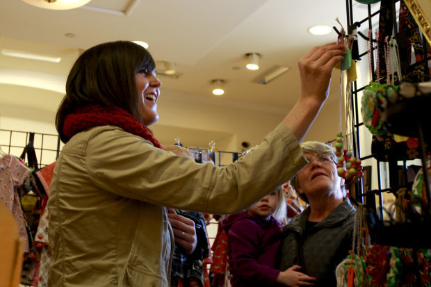 A mother picking something on the shop with grandma and baby