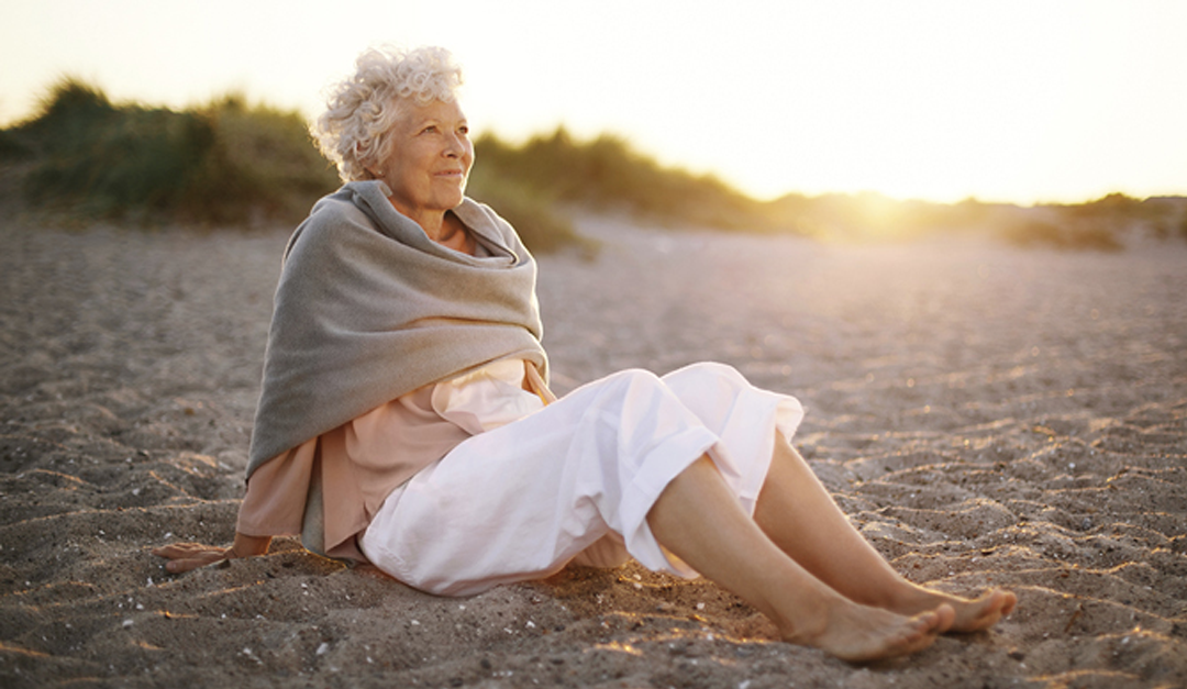senior woman while sitting on the sand