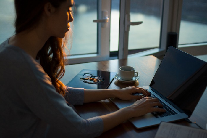 A woman typing her laptop