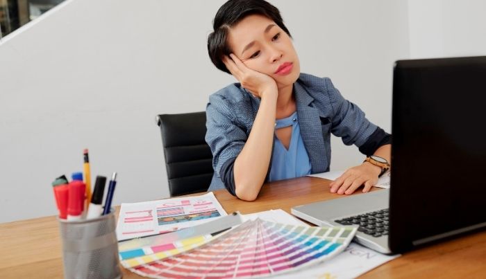 Woman thinking while in front of a laptop