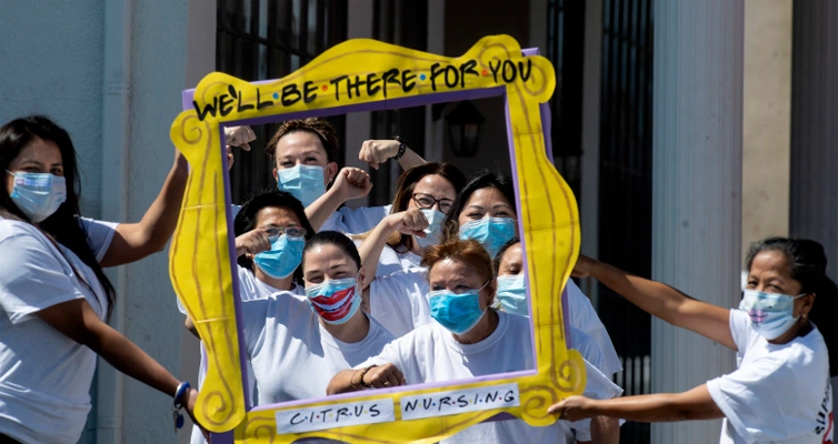 Group of nurses wearing facemask holding a frame