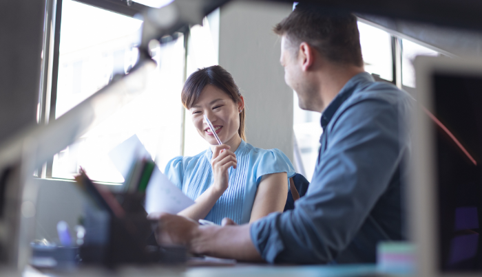 A man and a woman both smiling, having a conversation