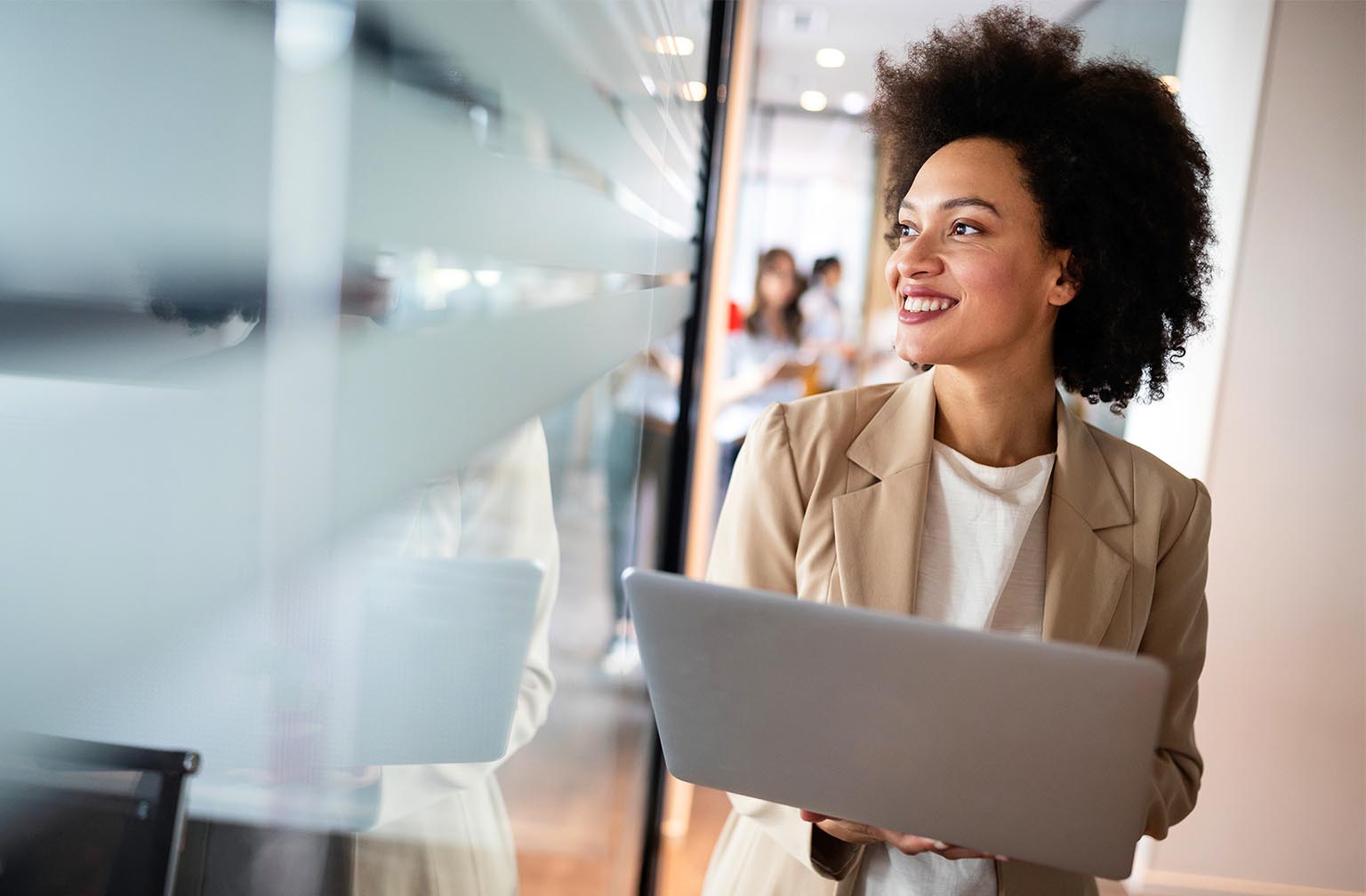 A career woman with short hair holding a laptop while looking aside